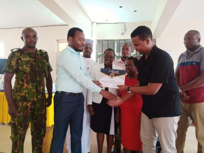 Galaxy Hospital HR head Rafiki Karisa (in blue shirt) presents the facility's IHRM Award to one of the Directors on December 22, 2023. The hospital was recognised for excellence in HR practices. PHOTO/PRESS POINT